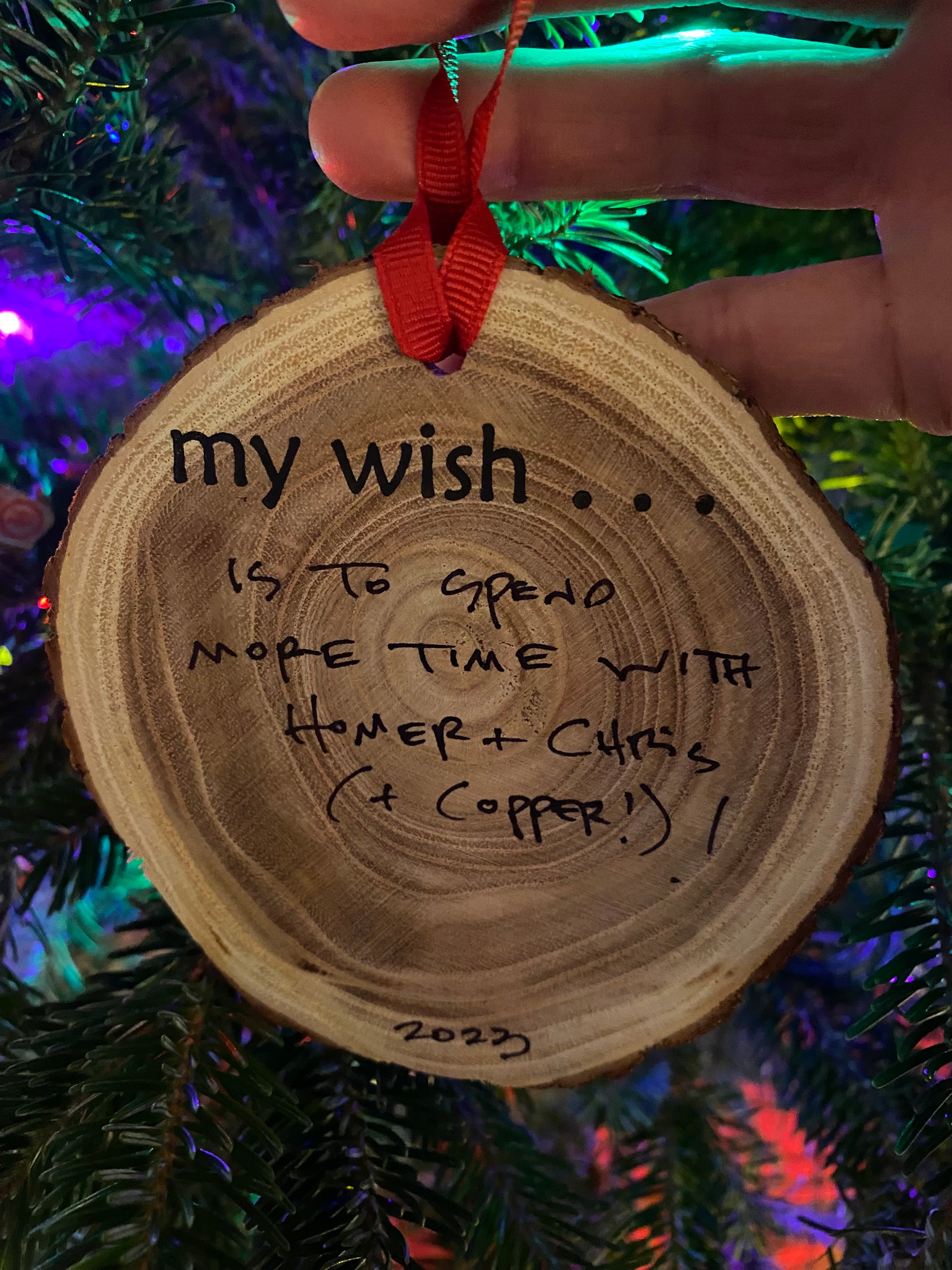 Wooden ornament with engraved message against a festive background